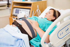 Mujer embarazade en cama al oficina de doctor