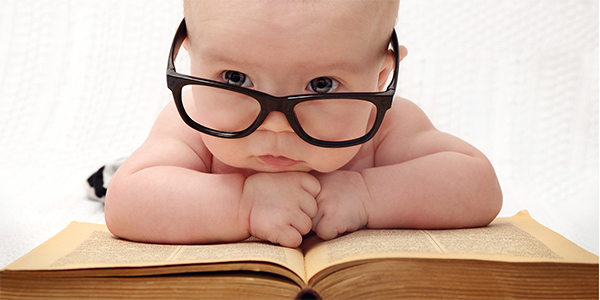 Bebé con gafas en libro grande