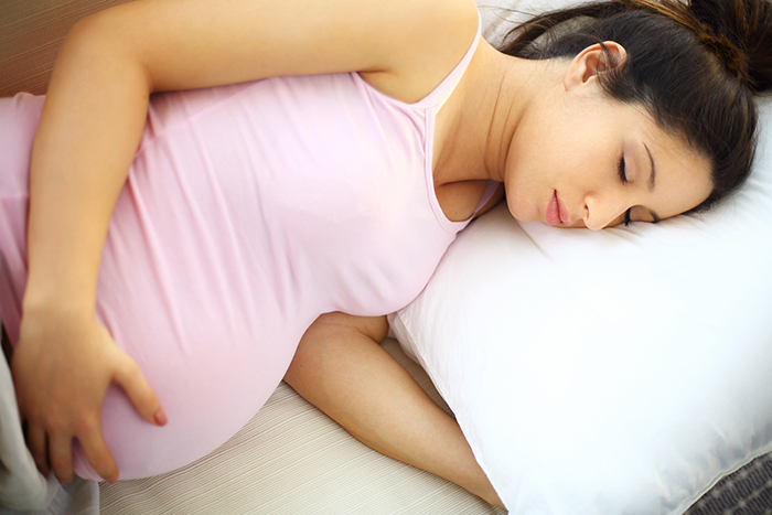 Una mujer embarazada que duerme del lado izquierdo.