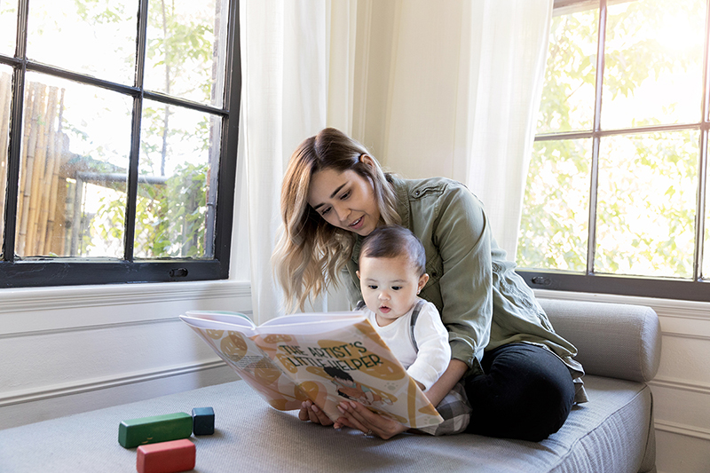 Mujer y bebé mirando un libro de imágenes.