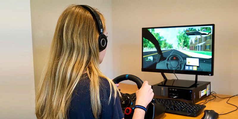 Adolescente al volante en frente de la evaluación de manejo virtual.