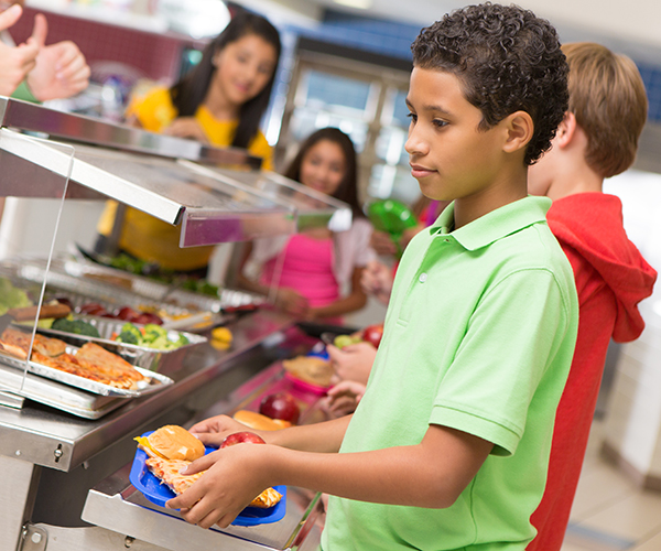 Los niños seleccionan sus comidas durante el almuerzo escolar.